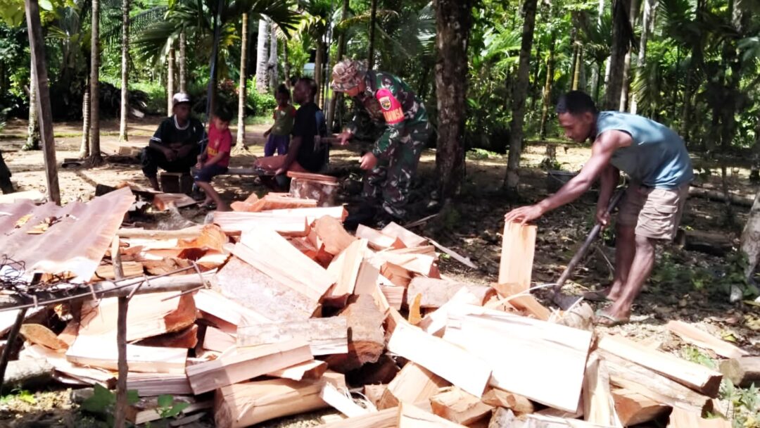 Ringankan Pekerjaan, Babinsa Numfor Bantu Warga Belah Kayu Bakar