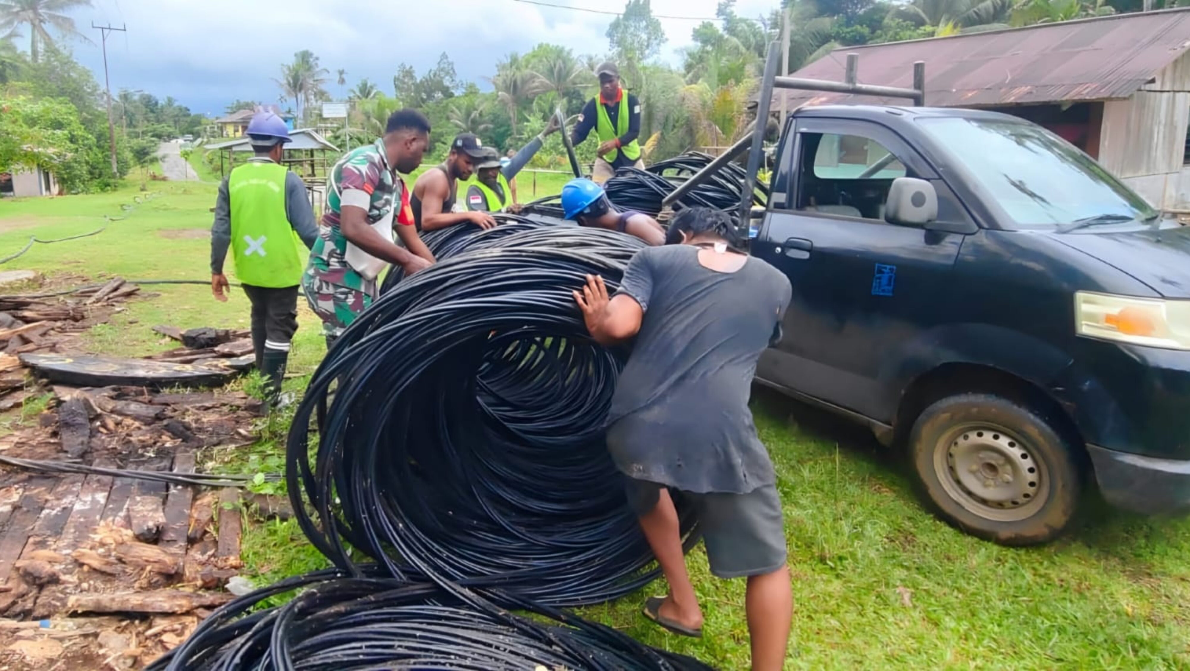 Terangi Kampung Benggor, Babinsa Bersama Warga Bantu Petugas PLN Pasang Jaringan Listrik