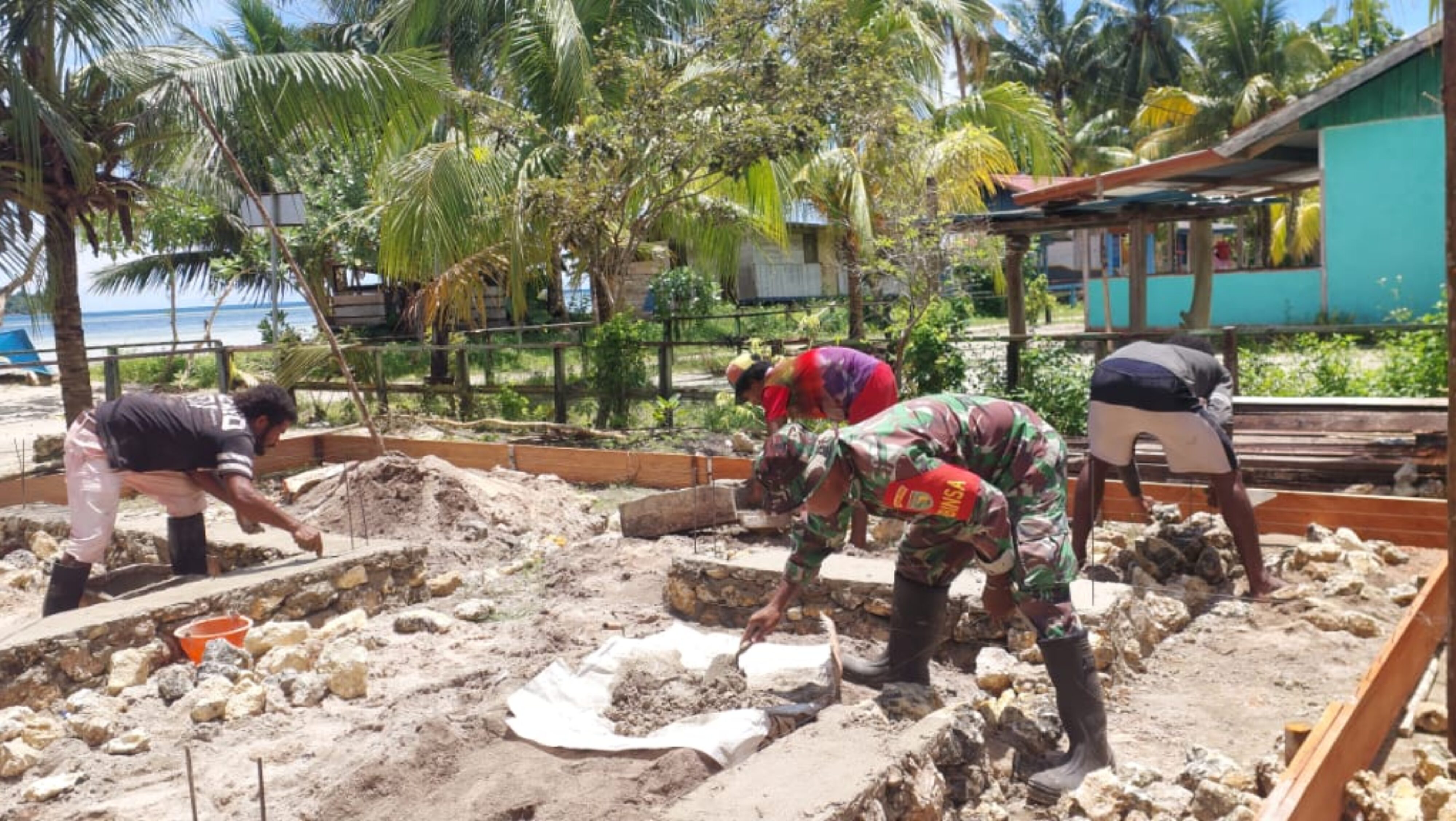 Babinsa Supiori Utara Dampingi Warga Membangun Pondasi Rumah di Supiori Barat