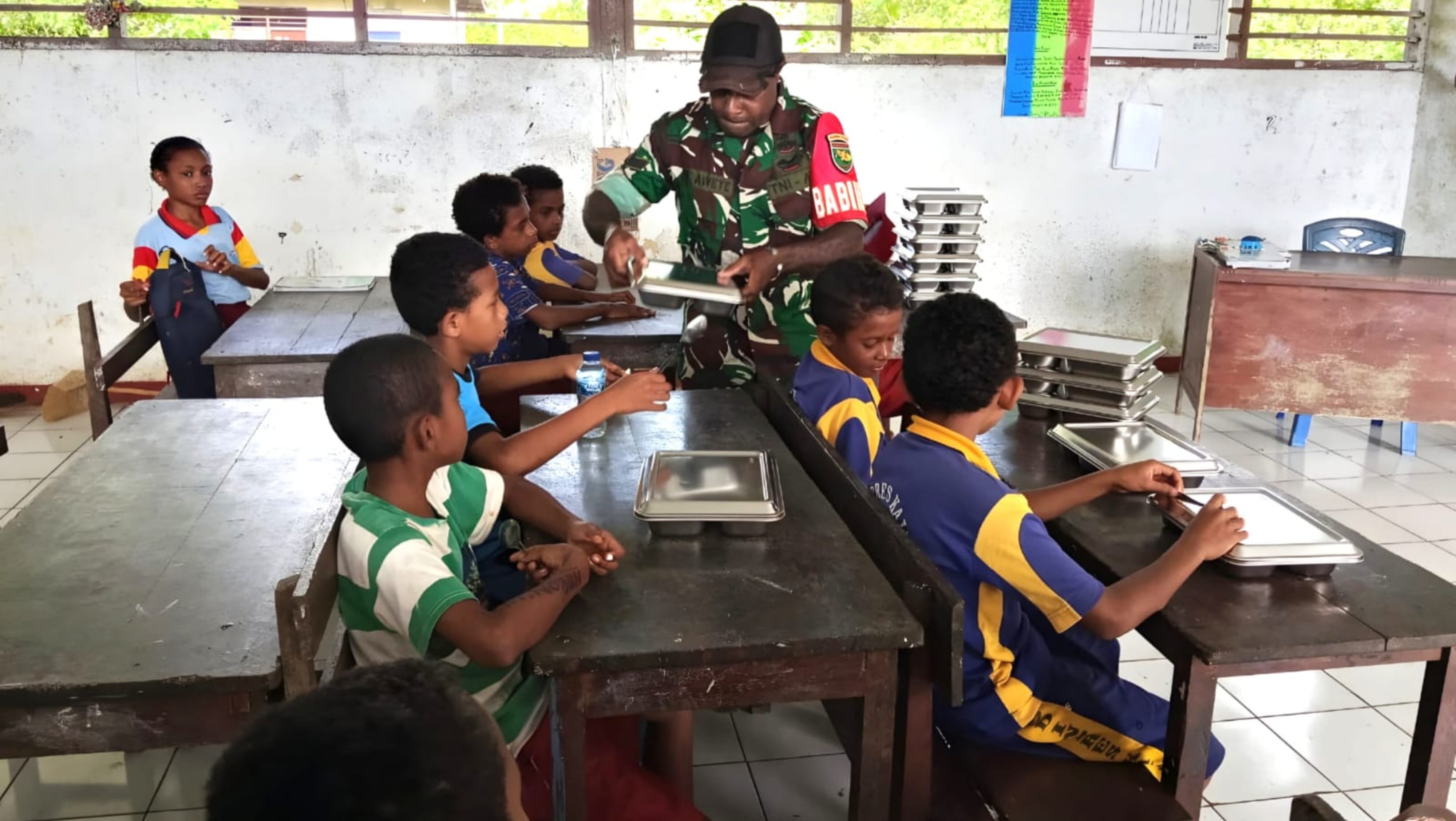 Dukung Kembang Anak, Babinsa Biak Timur Dampingi Penyaluran Makanan Bergizi Gratis