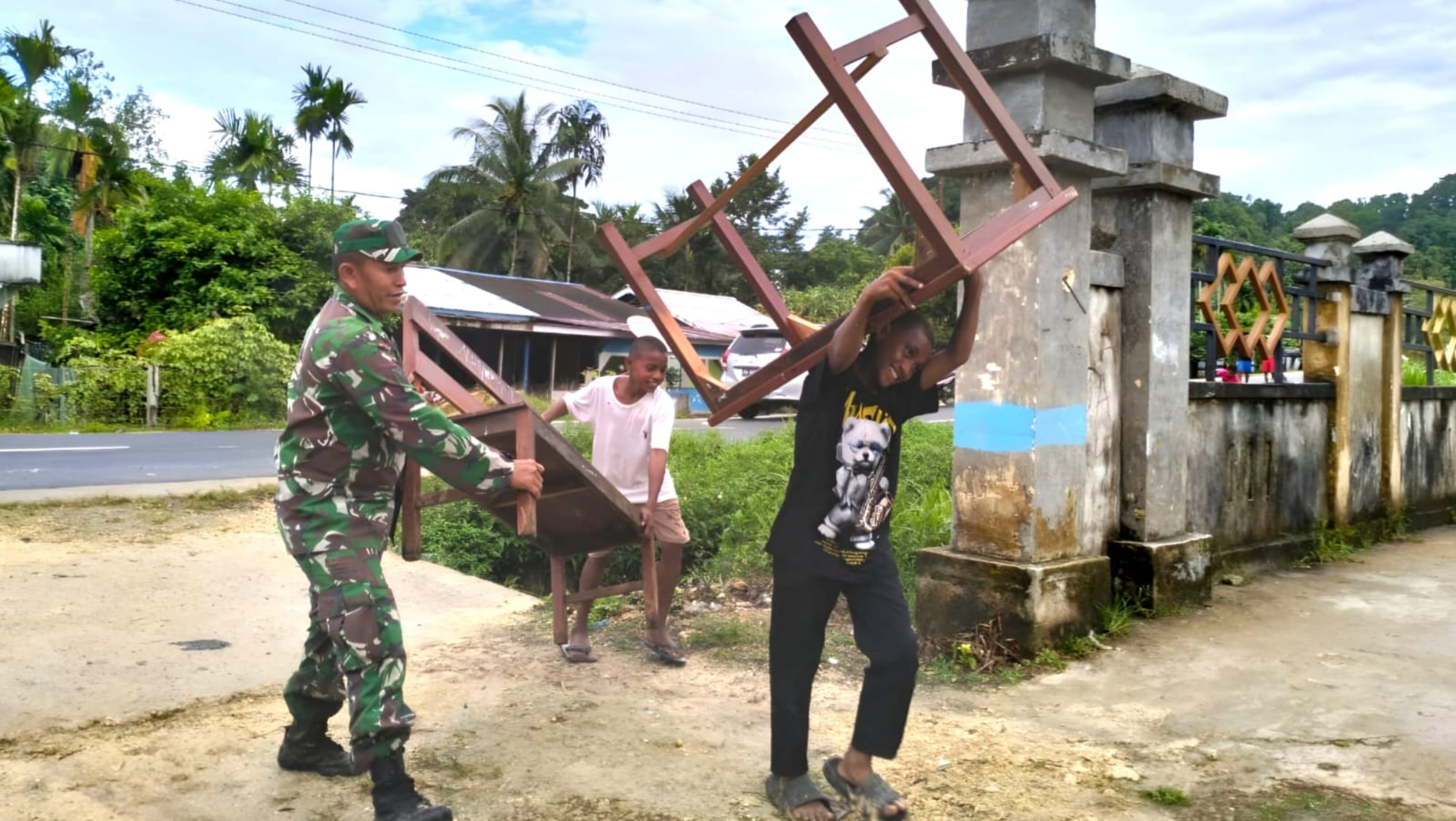Usai Diperbaiki, Babinsa dan Siswa SMP YPK Korido Angkat Meja Belajar ke Ruang Sekolah
