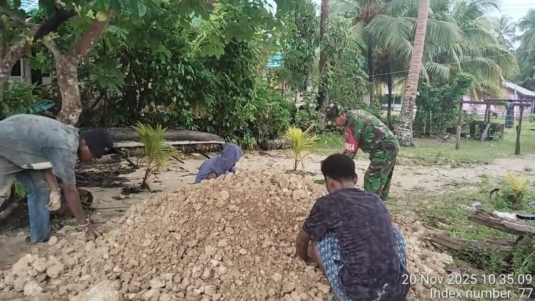 Babinsa Supiori Utara Bantu Ratakan Timbunan di Belakang Rumah Warga