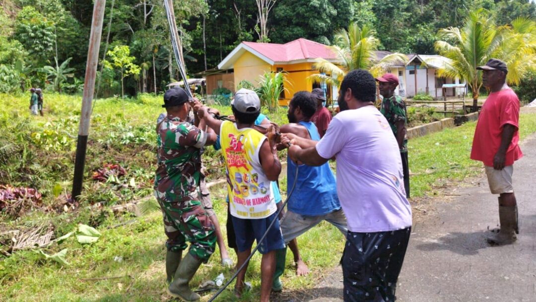 Babinsa Supiori Selatan Bantu Warga Tarik Tiang Listrik Akibat Hujan dan Angin Kencang