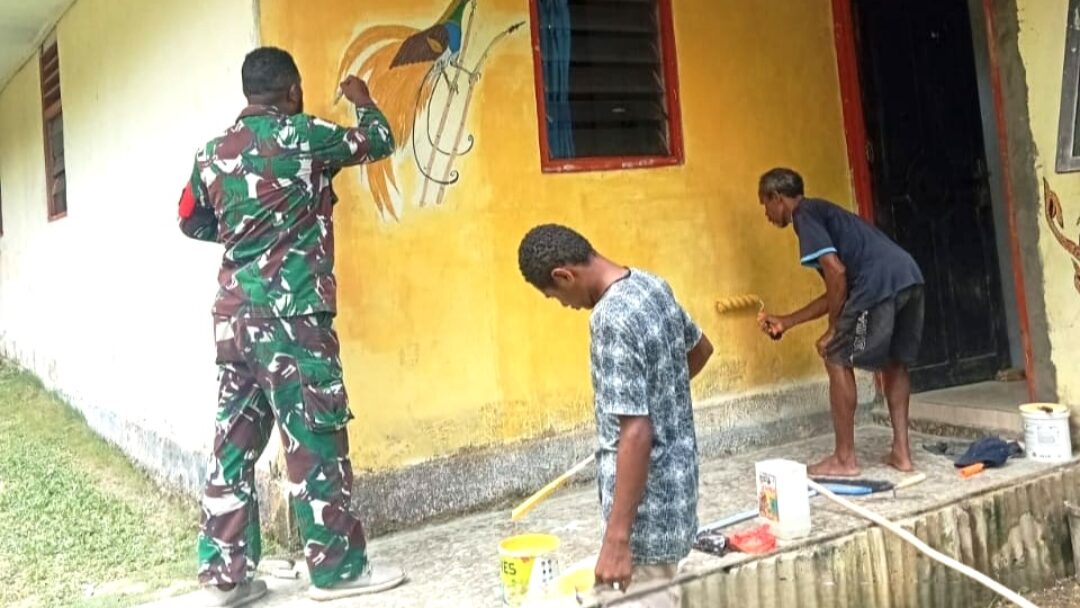 Babinsa Biak Barat dan Warga Bersama-Sama Cat Dinding Rumah