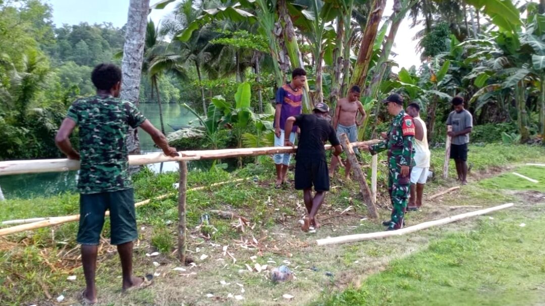 Babinsa Numfor Gotong-Royong Bersama Warga Perbaiki Pagar Kampung