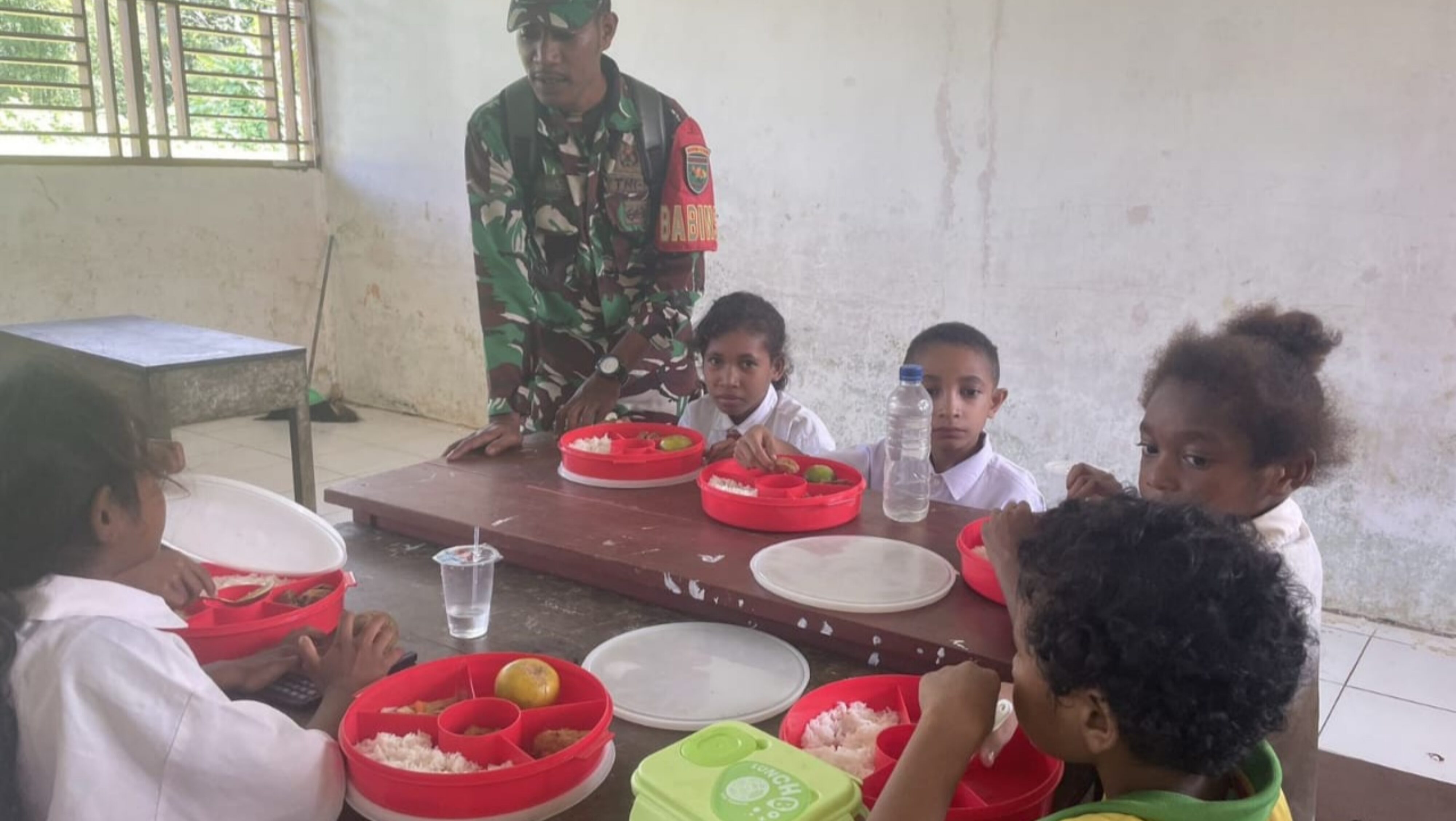 Dukung Gizi Anak, Babinsa Biak Timur Dampingi Pendistribusian Program MBG