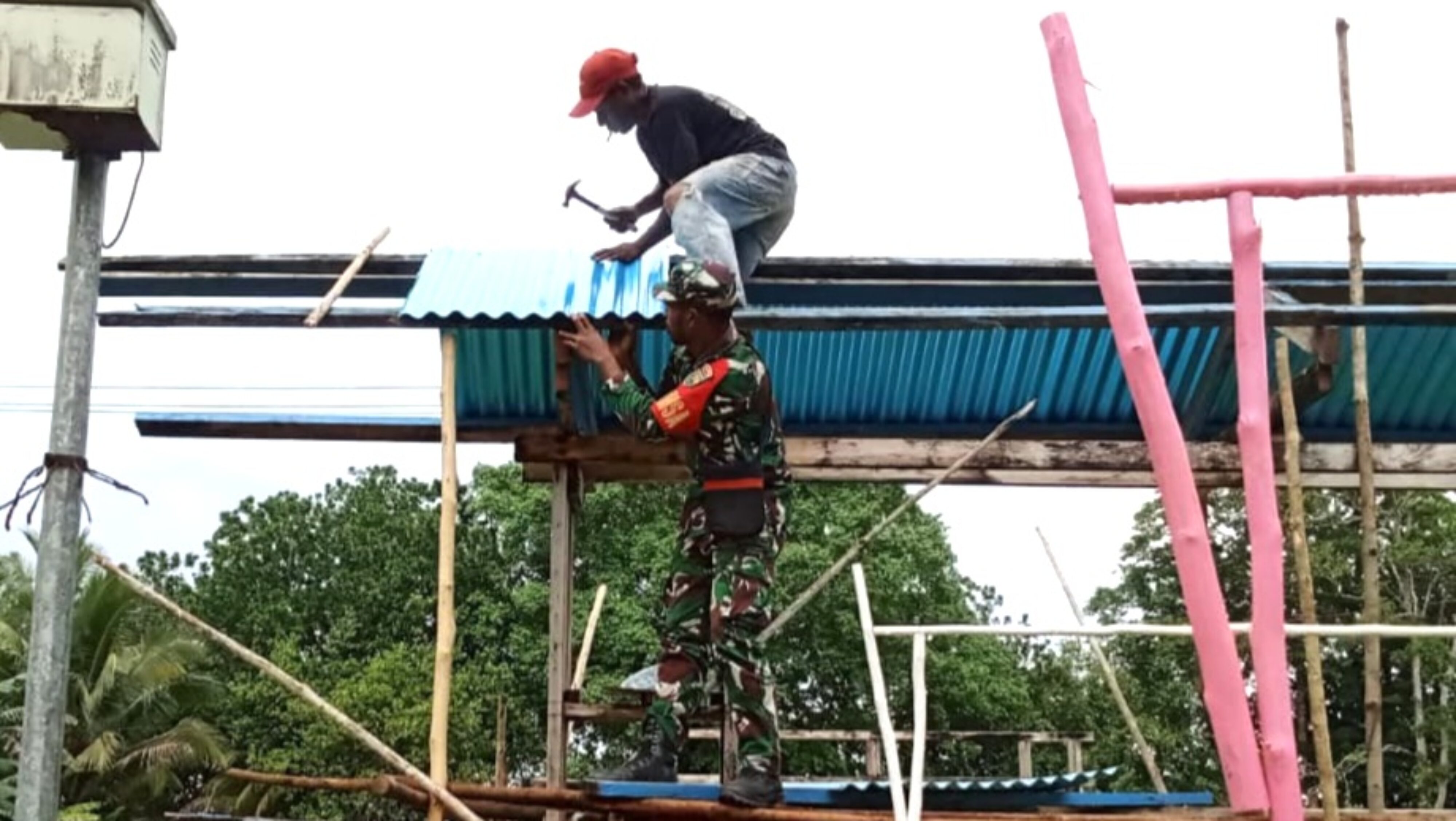 Babinsa Supiori Utara Gotong-Royong Pembuatan Gapura Kantor Klasis