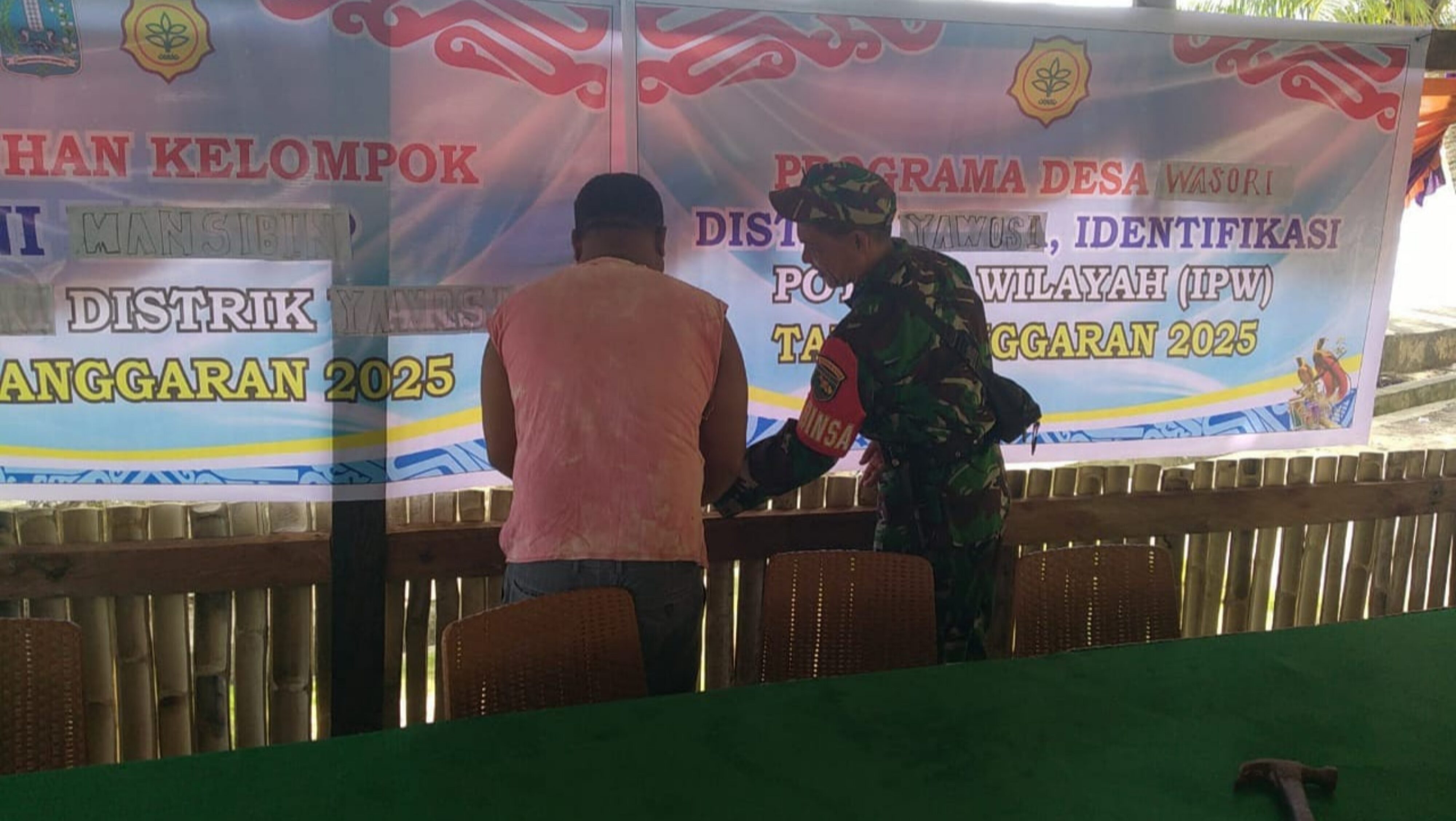 Babinsa Silaturahmi dan Bantu Pemasangan Baleho di Kampung Wasori