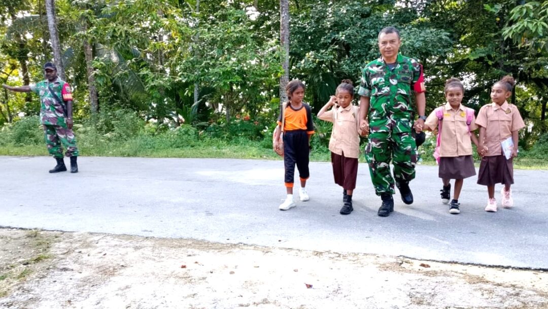 Babinsa Biak Timur Bantu Murid-Murid SDN Soryar Menyeberang Jalan