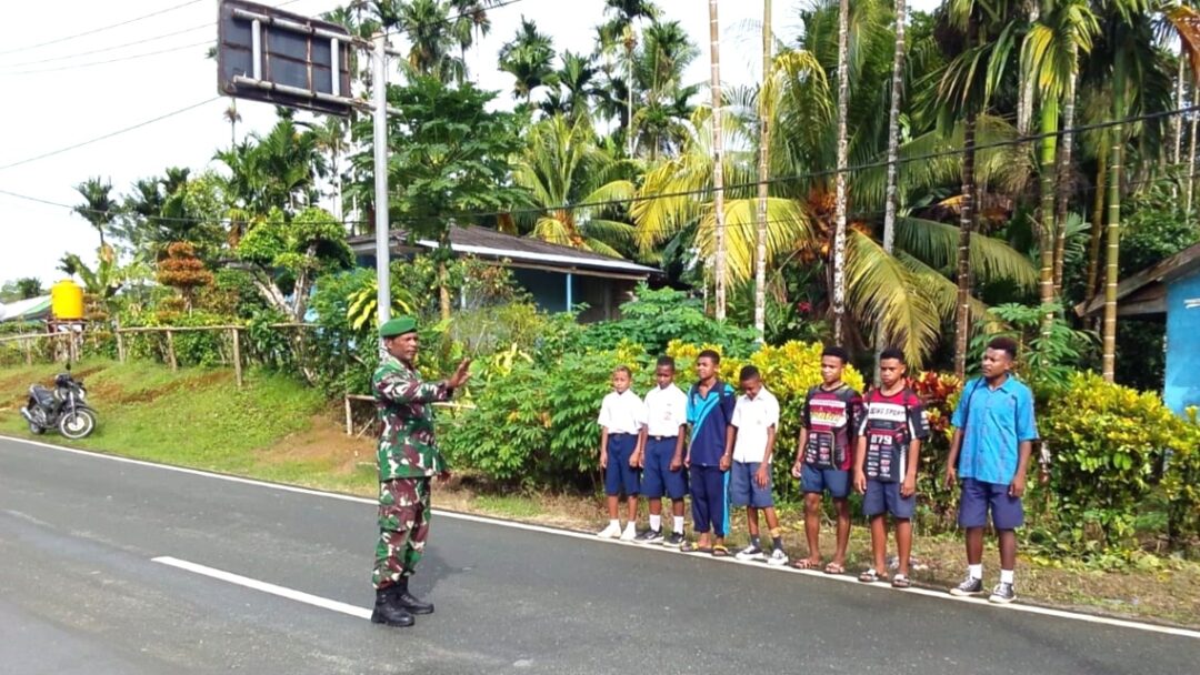 Babinsa Biak Barat Bantu Menyeberangkan Anak Sekolah di SMPN 1 Yomdori