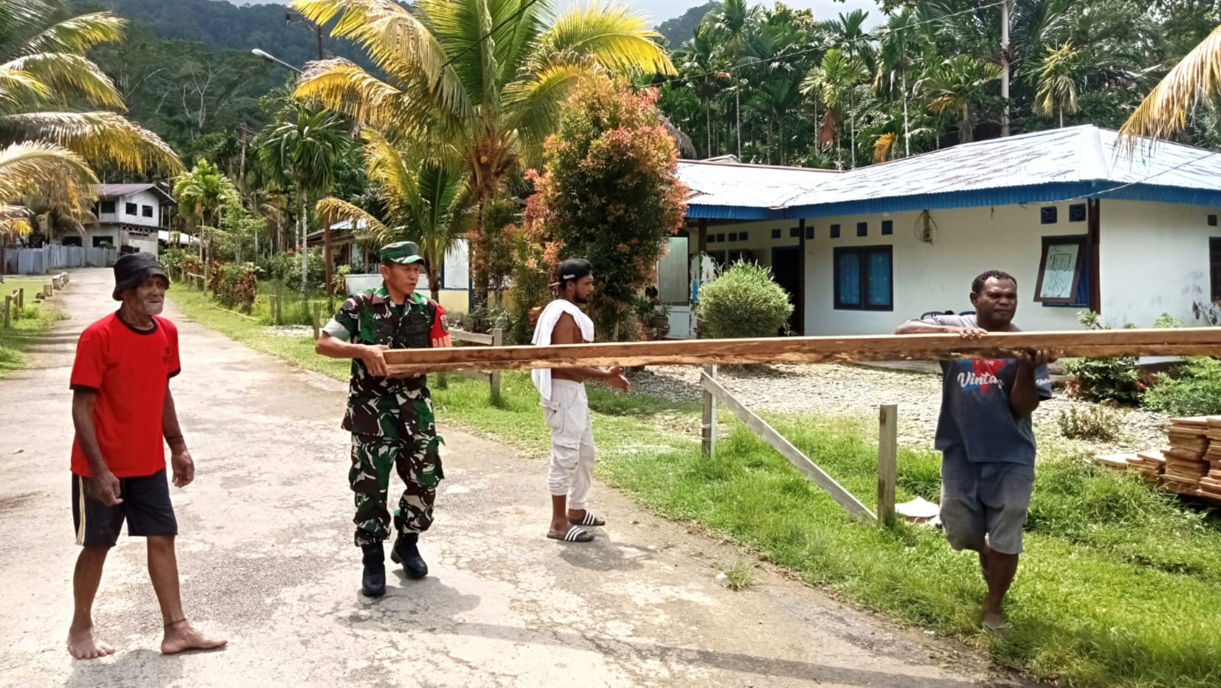 Babinsa Supiori Selatan Bantu Warga Angkut Kayu ke Dalam Truk