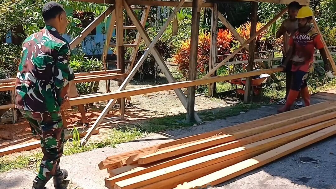 Babinsa Bantu Warga Siapkan Kayu untuk Pagar