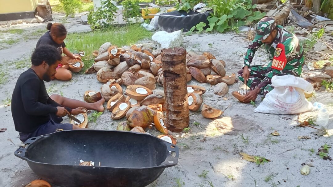 Babinsa Bantu Warga Mencongkel Daging Kelapa untuk Dibuat Kopra