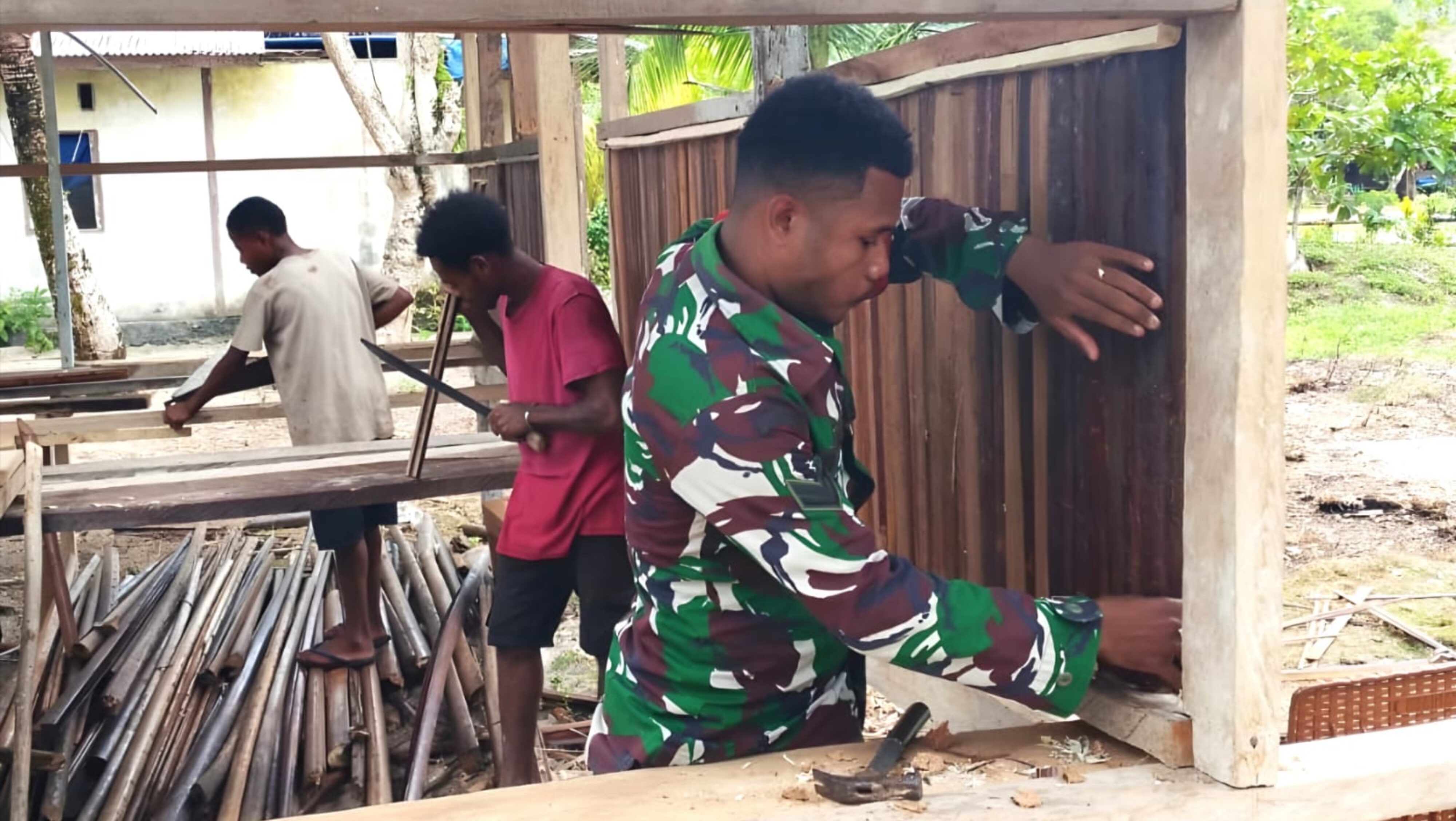 Babinsa Warsa Bantu Warga Pasang Dinding Rumah dari Pelepah Sagu