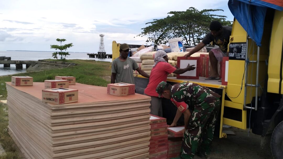 Babinsa Supiori Selatan Bantu Turunkan Material Renovasi Gedung SD di Pulau Aruri