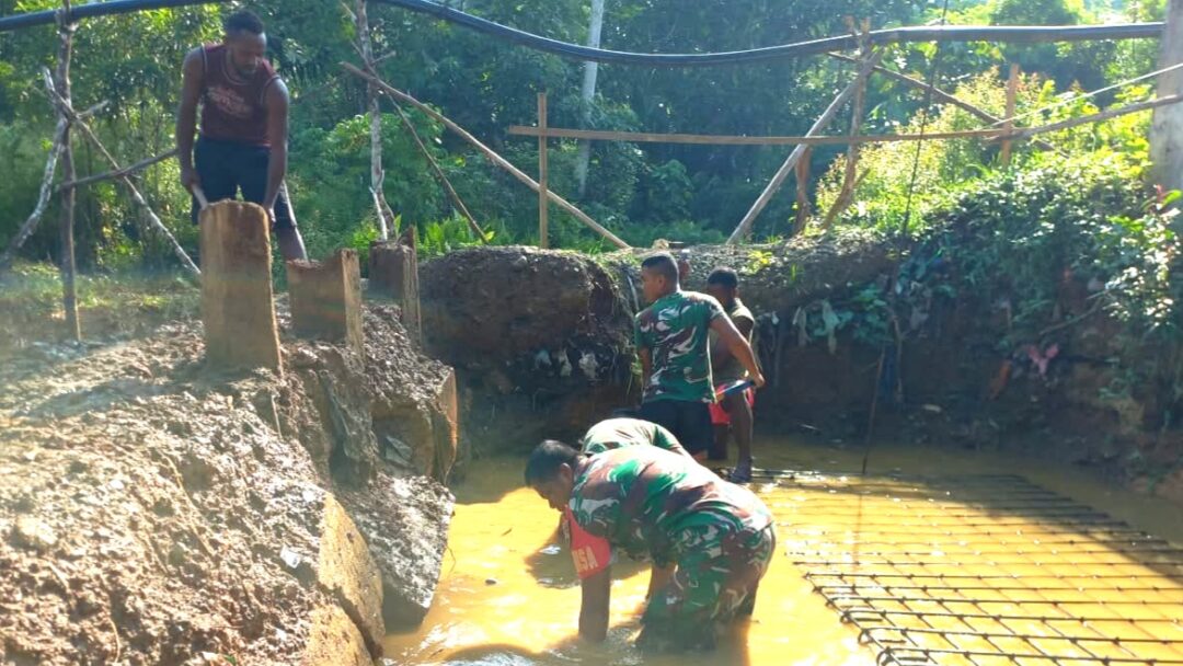 Babinsa Supiori Selatan Bantu Warga Gali Pondasi Jembatan Merah Putih di Kampung Odori