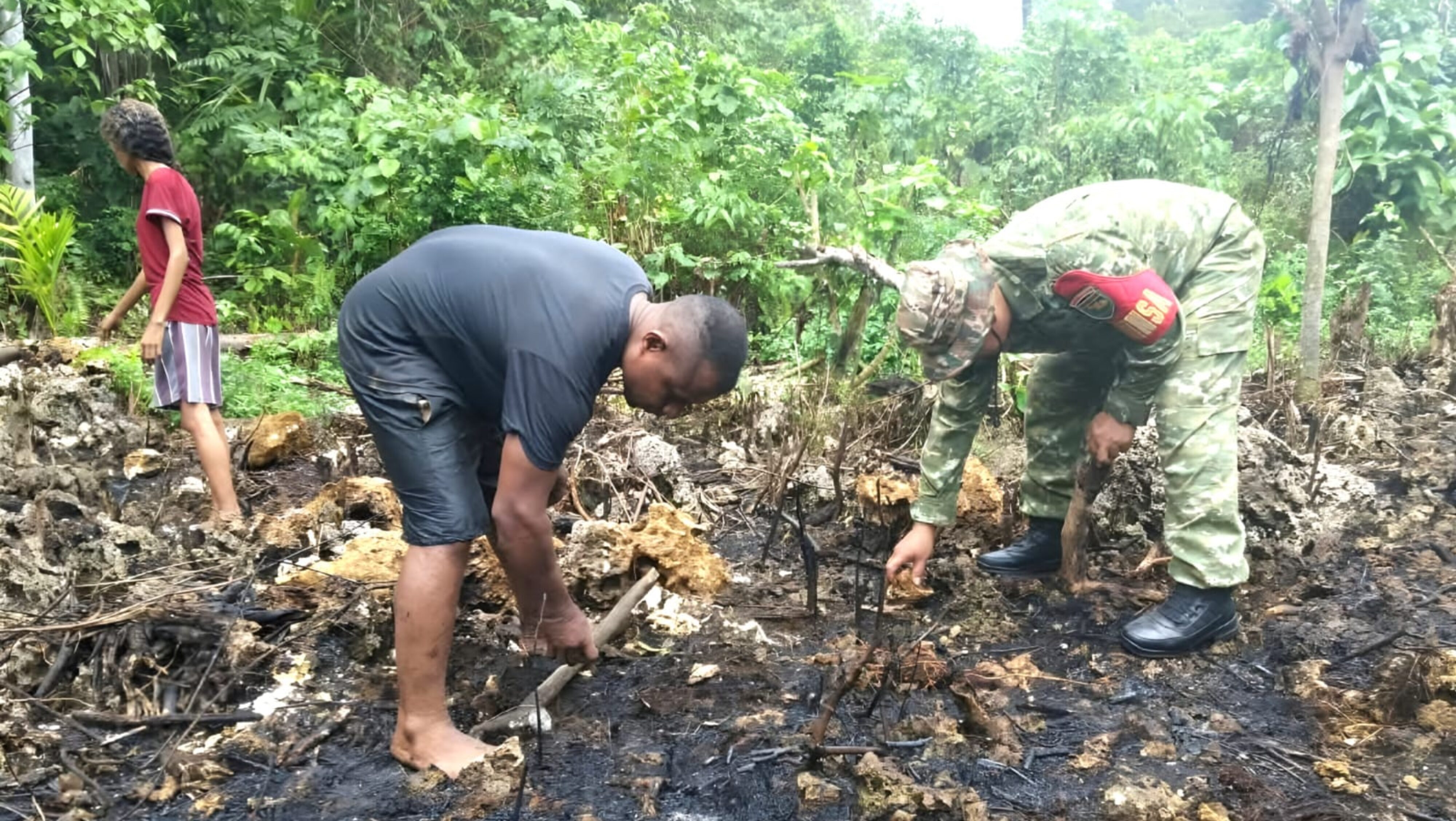 Babinsa Numfor Bantu Warga Kumpulkan Batu untuk Pondasi Dapur