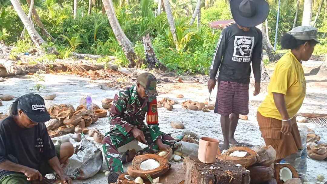 Babinsa Bantu Warga Mencongkel Daging Kelapa untuk Dijadikan Kopra