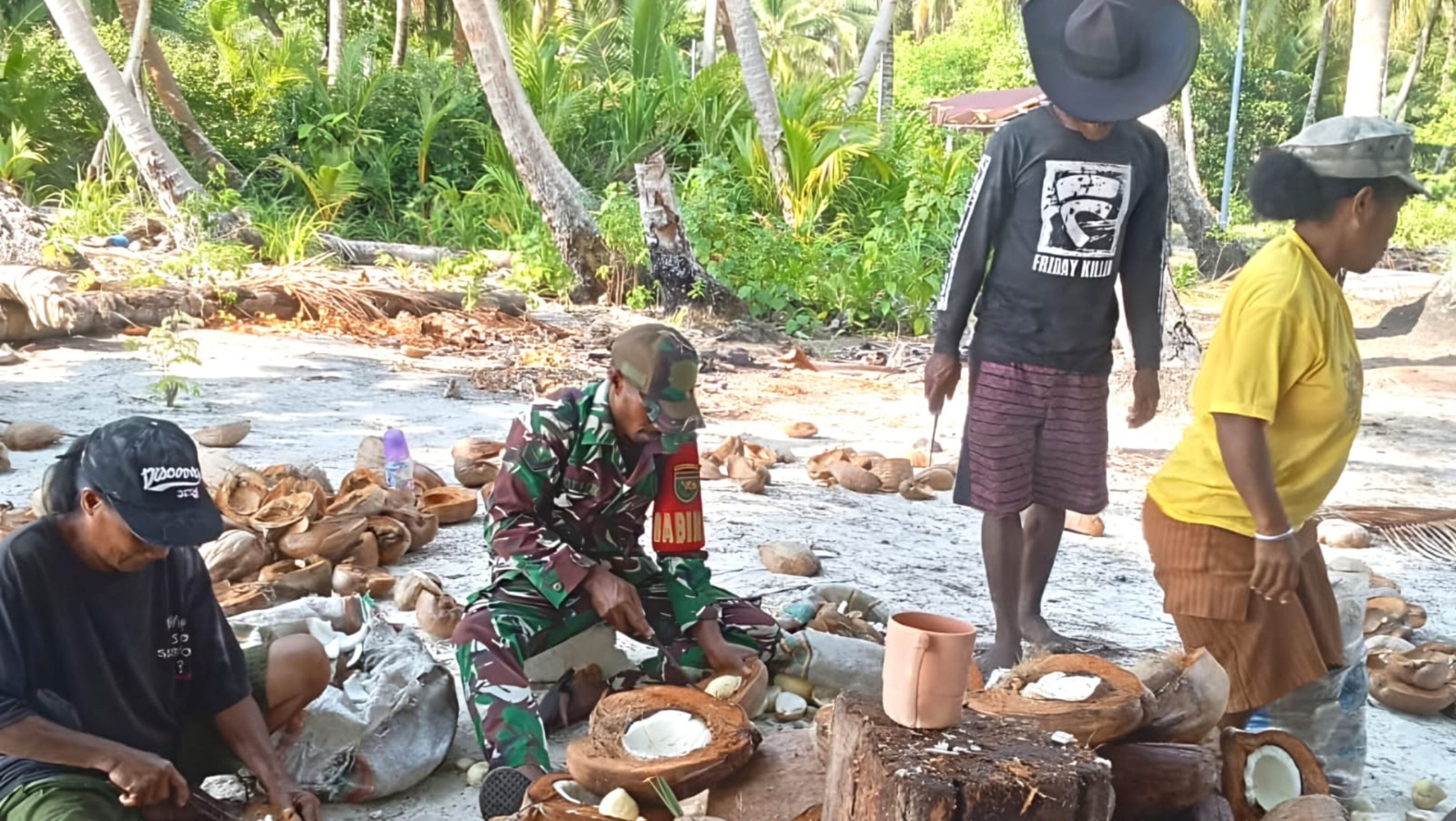 Babinsa Bantu Warga Mencongkel Daging Kelapa untuk Dijadikan Kopra