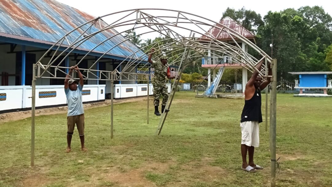 Babinsa Biak Utara Bantu Warga Pasang Tenda Persiapan Sidang Jemaat GKI Pniel Korem